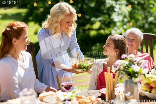 Image of happy family having dinner or summer garden party