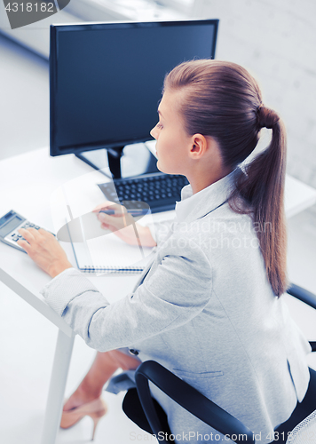 Image of businesswoman with notebook and calculator