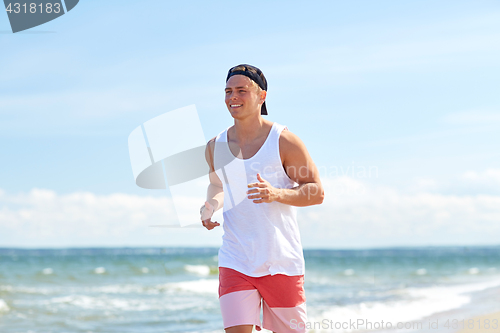 Image of happy man running along summer beach