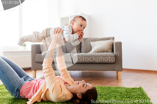 Image of happy young mother playing with baby at home
