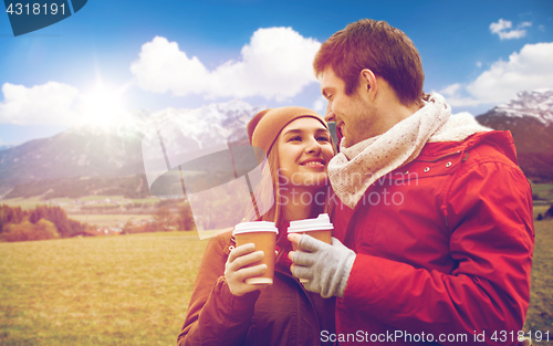 Image of happy couple with coffee cups over alps mountains