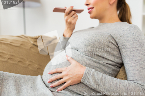 Image of pregnant woman using voice recorder on smartphone