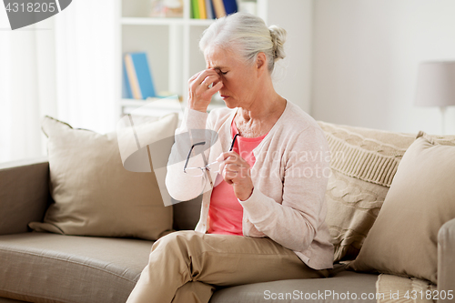 Image of senior woman with glasses having headache at home