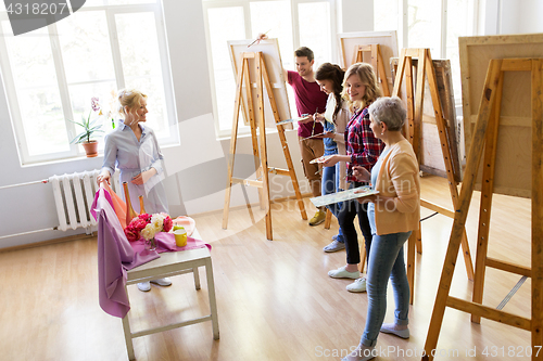 Image of students and teacher with still life at art school