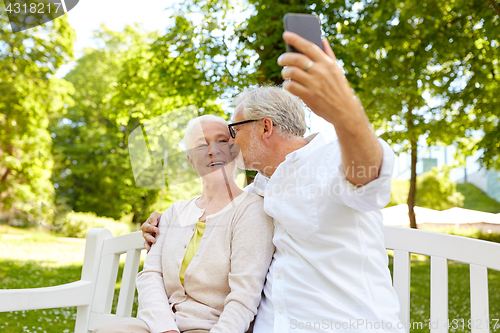 Image of senior couple with smartphone taking selfie