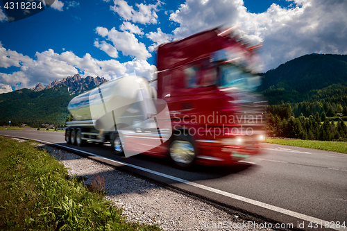 Image of Fuel truck rushes down the highway in the background the Alps. T