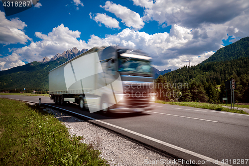 Image of Fuel truck rushes down the highway in the background the Alps. T