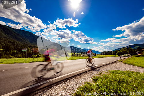 Image of Cyclists riding a bicycle on the road in the background the Dolo