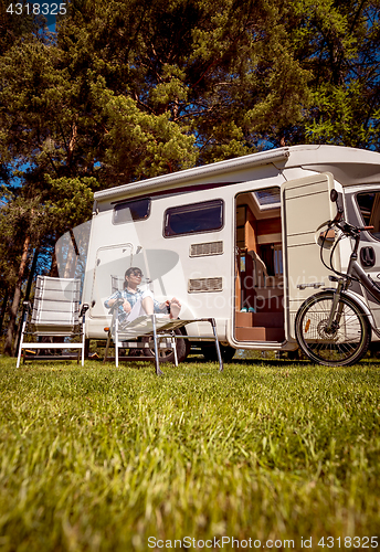 Image of Woman resting near motorhomes in nature. Family vacation travel,