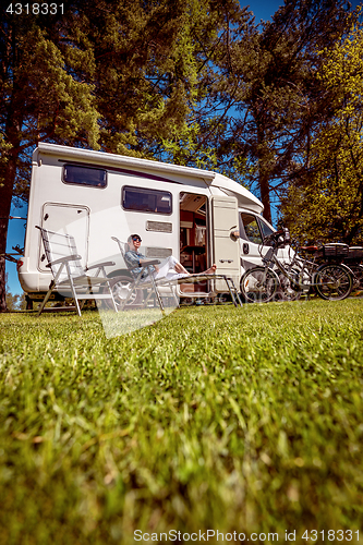 Image of Woman resting near motorhomes in nature. Family vacation travel,