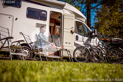 Image of Woman resting near motorhomes in nature. Family vacation travel,