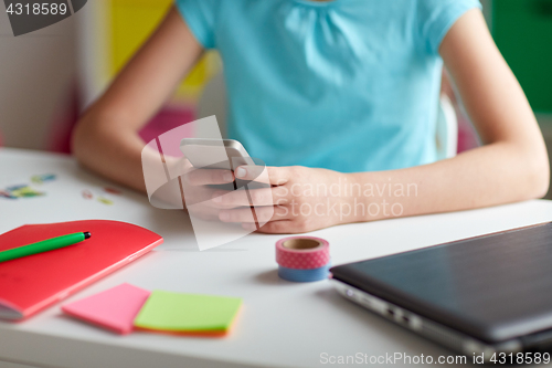 Image of girl with smartphone messaging at home