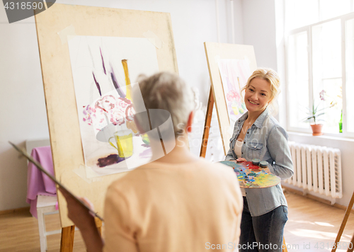 Image of artist women with easels painting at art school