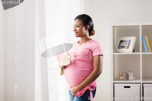 Image of happy african american pregnant woman with flowers