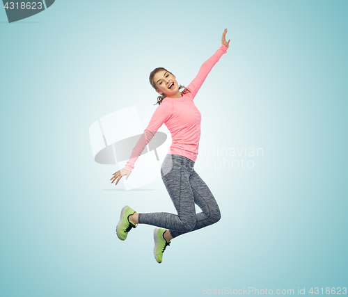 Image of happy smiling sporty young woman jumping in air