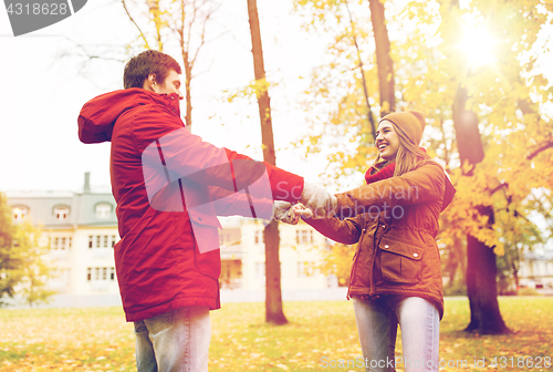 Image of happy young couple having fun in autumn park