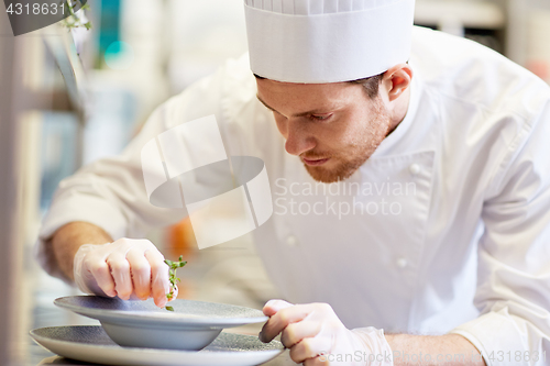 Image of happy male chef cooking food at restaurant kitchen