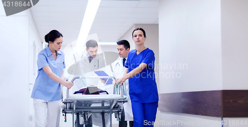 Image of medics with woman on hospital gurney at emergency