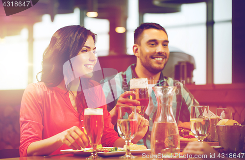 Image of friends dining and drinking beer at restaurant