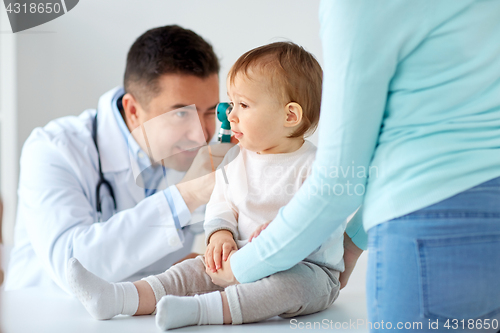 Image of doctor with otoscope checking baby ear at clinic