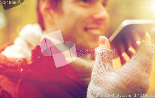 Image of close up of man recording voice on smartphone
