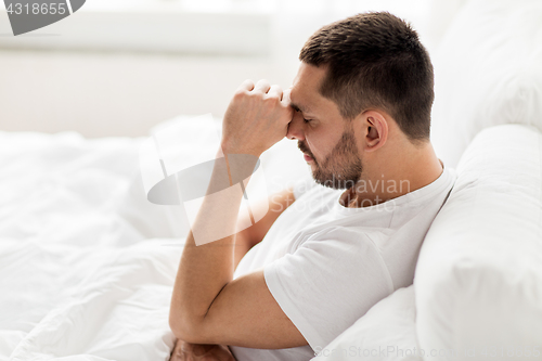 Image of stressed man in bed at home