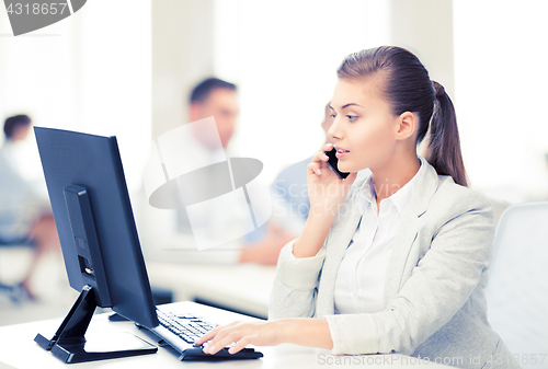 Image of businesswoman with smartphone in office