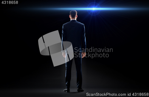 Image of businessman in suit from back with laser light