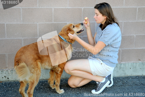 Image of Female feeding dog.