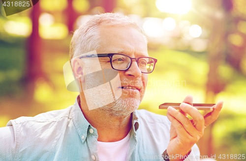 Image of old man using voice command recorder on smartphone