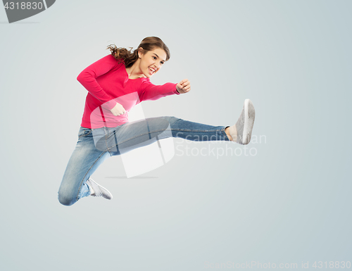 Image of smiling young woman jumping in air