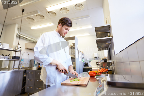 Image of happy male chef cooking food at restaurant kitchen