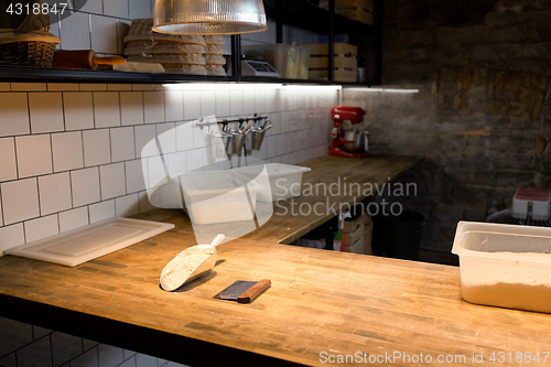 Image of dough and baking tools on bakery kitchen table