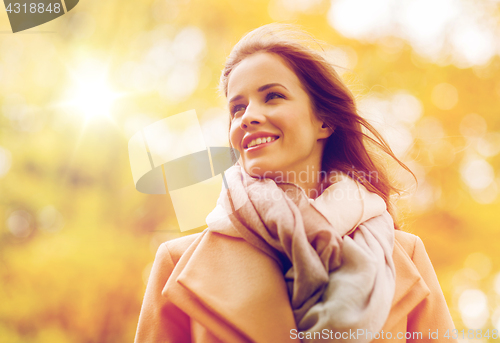Image of beautiful happy young woman smiling in autumn park