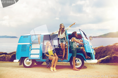 Image of happy hippie friends in minivan car on island