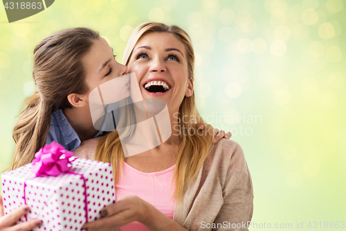 Image of girl giving birthday present to mother over lights