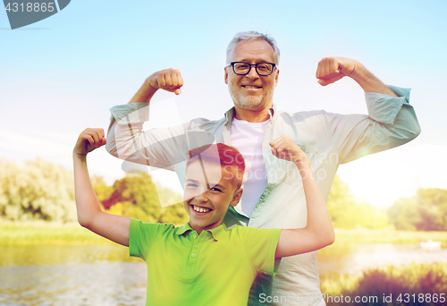 Image of happy grandfather and grandson showing muscles