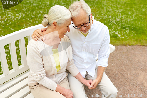 Image of happy senior couple hugging in city park