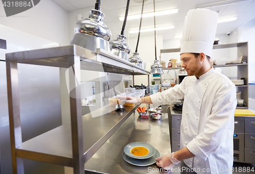 Image of happy male chef cooking food at restaurant kitchen