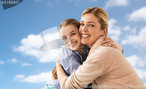 Image of happy family of girl and mother hugging over sky