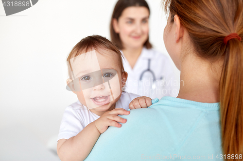 Image of close up of happy baby with mother and doctor