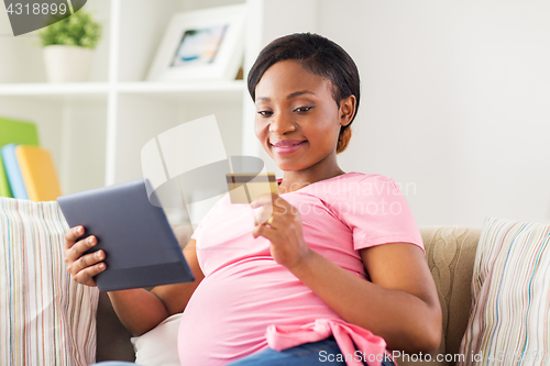 Image of pregnant woman with tablet pc and credit card