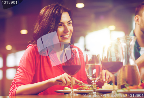 Image of happy woman having dinner at restaurant