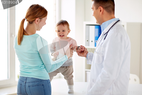 Image of happy woman with baby and doctor at clinic