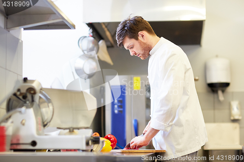 Image of happy male chef cooking food at restaurant kitchen