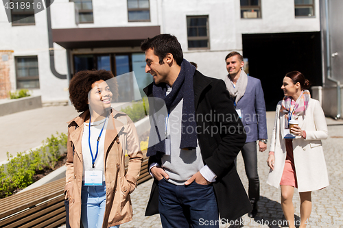 Image of people with coffee and conference badges in city