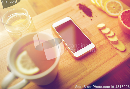 Image of smartphone with cup of lemon tea, honey and ginger