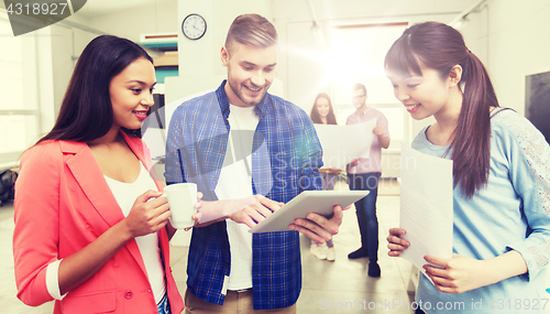 Image of creative team with tablet pc and papers at office