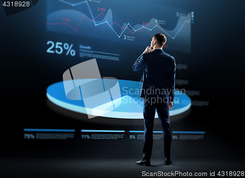 Image of businessman looking at virtual chart hologram