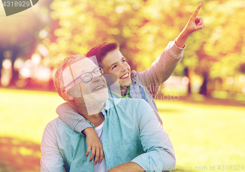 Image of grandfather and boy pointing finger at summer park